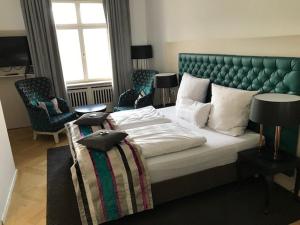贝尔恩里德Schloss Höhenried的一间卧室配有一张大床和绿色床头板