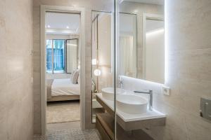 马贝拉Casona Seis Lunas Apartment的一间带水槽和镜子的浴室以及一张床