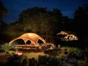 石垣岛Ecostay Glamping Rainbow Forest的晚间在花园内带帐篷的野餐桌