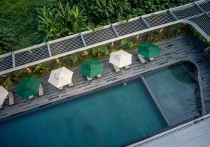 河内Fraser Residence Hanoi的享有带椅子和遮阳伞的游泳池的上方景致