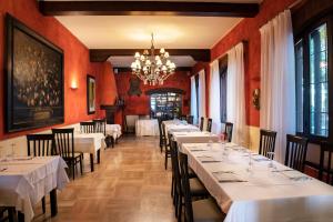 科洛尔诺洛坎达斯汤达酒店的餐厅配有白色的桌椅和吊灯