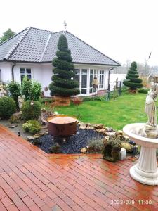 耶弗尔Ferienwohnung Christine的庭院内带喷泉的花园的房子