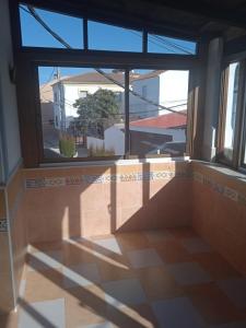 隆达Apartamento Cerro De Las Salinas的一间空房间,设有大窗户和瓷砖地板