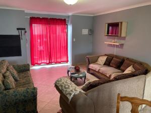 斯瓦科普蒙德Daffodil Self Catering and Accommodation B的客厅设有两张沙发和一个红色窗户