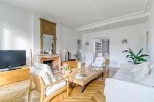 塞纳河畔讷伊Superbe appart de 129m2, 3 ch-Neuilly 2 min Paris的客厅配有沙发和桌子