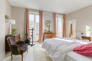 塞纳河畔讷伊Superbe appart de 129m2, 3 ch-Neuilly 2 min Paris的一间卧室配有一张床、一张桌子和一把椅子