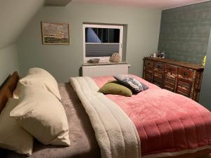 德兰斯克Altes Kapitänshaus的卧室配有带枕头的床铺和窗户。