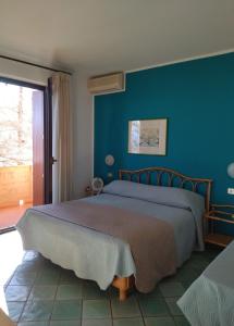西尔米奥奈伊尔比安克斯皮诺旅馆的一间卧室设有一张蓝色墙壁的大床