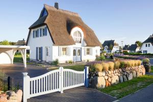 富伦多夫Holiday house, Fuhlendorf的白色的房子,有茅草屋顶和栅栏