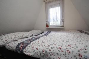 PerlinHoliday home on Dümmer See, Perlin的卧室内的一张带花卉棉被的床
