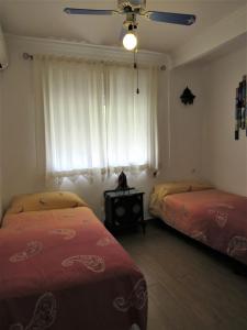 桑卢卡尔-德巴拉梅达El apartaito的一间卧室设有两张床和窗户。