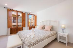 克里斯托港Ca Na Lola的卧室配有白色的床和窗户。
