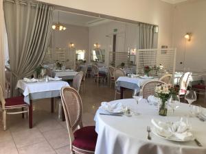 NangisLogis - Hostellerie Le Chatel Nangis的餐厅配有白色的桌椅和镜子