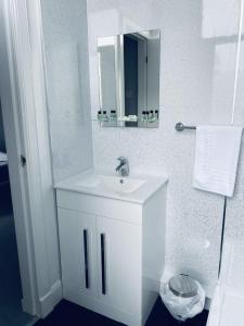 基尔马诺克The Portmann Hotel的白色的浴室设有水槽和镜子