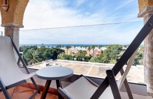 萨阿拉德洛斯阿图内斯Meliá Zahara Resort & Villas的阳台配有桌椅,享有海景。