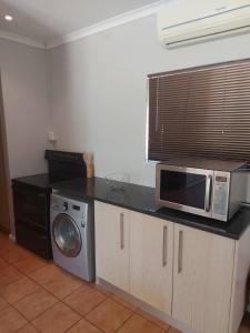 德班维尔Mimosa Self-Catering Studio Durbanville的厨房配有微波炉和台面
