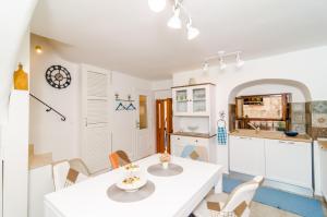 杜布罗夫尼克Holiday Home Tezoro Royal的厨房以及带白色桌椅的用餐室。