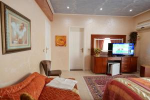 萨兰达Hotel Lindi的一间卧室配有一张床和一台电视
