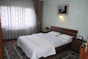 ÇekirgeViP Apartments的卧室设有一张白色大床和一扇窗户。