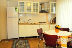 ÇekirgeViP Apartments的厨房配有桌子和白色冰箱。