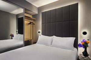 伦敦AMANO Covent Garden的一间卧室设有两张床和大镜子