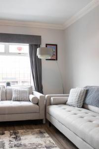 UrmstonTrafford Terrace Davyhulme的客厅配有2张白色沙发和窗户
