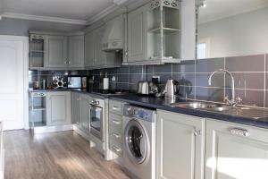 UrmstonTrafford Terrace Davyhulme的白色的厨房配有水槽和洗碗机