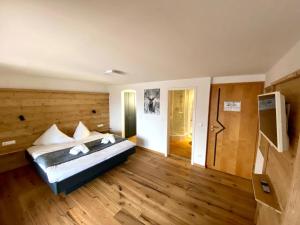 阿尔高内的伊门施塔特Hotel Bergstätter Hof的铺有木地板的客房内设有一间卧室和一张床。