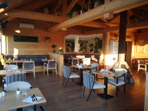 蒙索莱米讷Le Konine - Hotel & Bar & Restaurant的餐厅设有木制天花板和桌椅