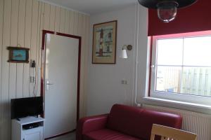 德科克斯多普boerderij de duinen 115的客厅设有红色的沙发和窗户。