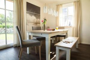 富伦多夫Holiday house, Fuhlendorf的一间配备有白色桌椅的用餐室