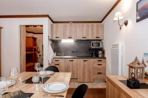 里雾诗Family Apt With Superb View On The Mont Blanc的厨房配有带酒杯的木桌