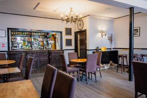 斯佩河畔格兰敦The Ben Mhor Hotel, Bar & Restaurant的一间带桌椅的餐厅和一间酒吧