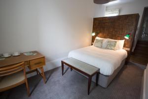 伯明翰高地联排别墅酒店的一间卧室配有一张床、一张桌子和一张书桌