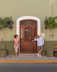梅里达Kuka y Naranjo的站在门前的男人和女人