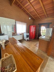 康塞高伊比蒂波卡Casa Tapera Nova的厨房配有木桌和红色冰箱。