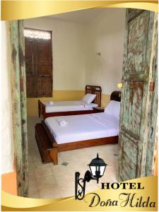 San MartínHotel Doña Hilda的带窗户的客房内设有两张单人床。