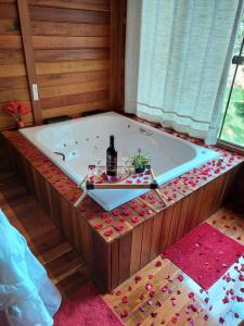 新文达移民镇Recanto Della Mata的浴缸内备有一瓶葡萄酒和眼镜
