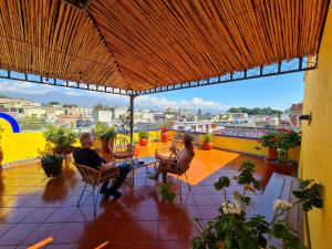 瓦哈卡市Hotel Suites Del Centro的坐在阳台上的男人和女人