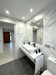 卡达韦多Apartamentos el Oligo的白色的浴室设有水槽和镜子