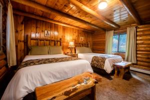 莫兰海彻度假酒店的小木屋内一间卧室,配有两张床