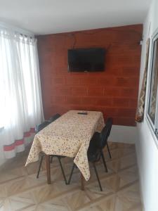 卡法亚特Hostal Candelaria的一张桌子、椅子和墙上的电视
