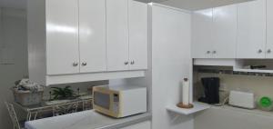 圣詹姆斯Annwin Annex的厨房配有白色橱柜和微波炉