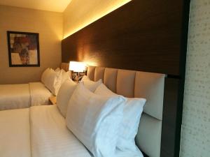 危地马拉危地马拉假日酒店的酒店的客房 - 带2张带白色枕头的床