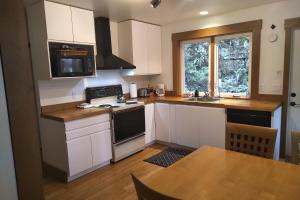 Madeira ParkMoon Dance Cabin的厨房配有白色橱柜和炉灶烤箱。