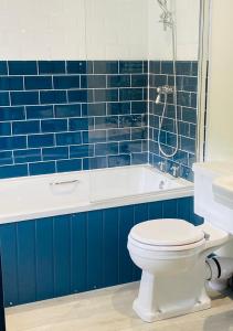 托波因特The Wilcove Inn的蓝色瓷砖浴室设有卫生间和浴缸