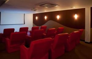 弗洛里亚诺波利斯Flat 3 suites frente mar的一间会议室,配有红色椅子和屏幕