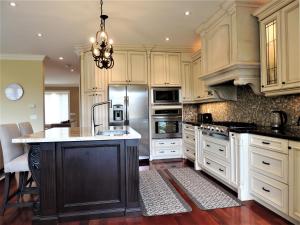 多伦多iResidence in Toronto - LUX 3 Bedroom Vacation Home的一间设有白色橱柜和黑岛的大厨房