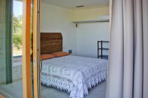 SantʼAnnaHoliday home Biocasa Fabiana, Portoferraio Magazzini的一间卧室设有一张床和一个滑动玻璃门