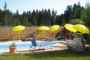 WasserhofenAdults only apartment with pool的一个带四把黄色遮阳伞和椅子的游泳池以及一组桌子